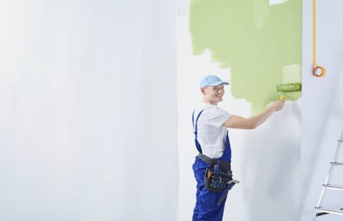 Person streicht die Wand grün