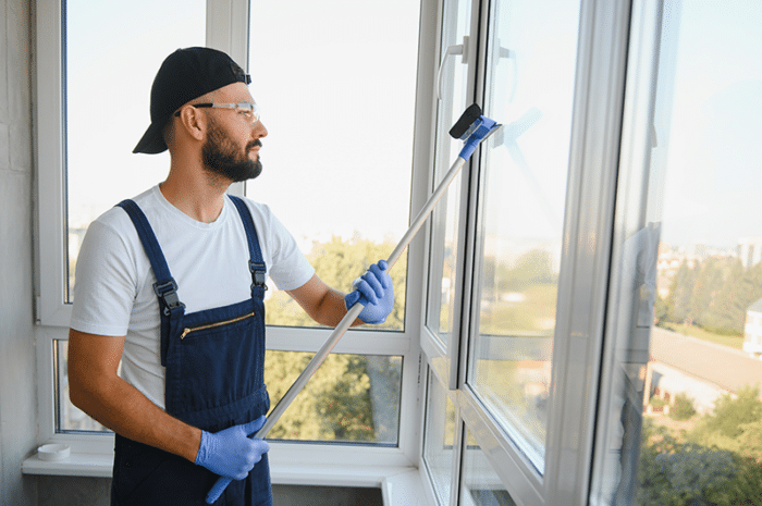 Gebäudereinigung, Mann reinigt Fenster